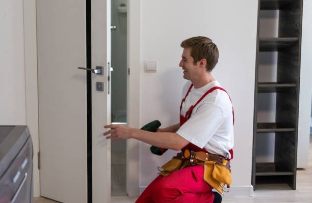 A man is installing a lock on a wooden door.