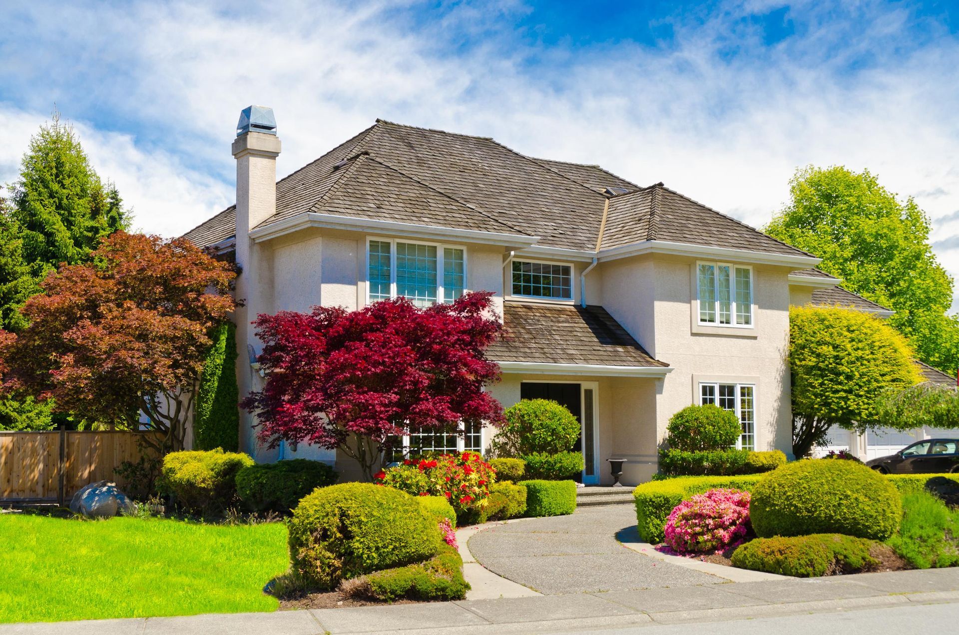 a large white house with a lush green lawn and trees in front of it