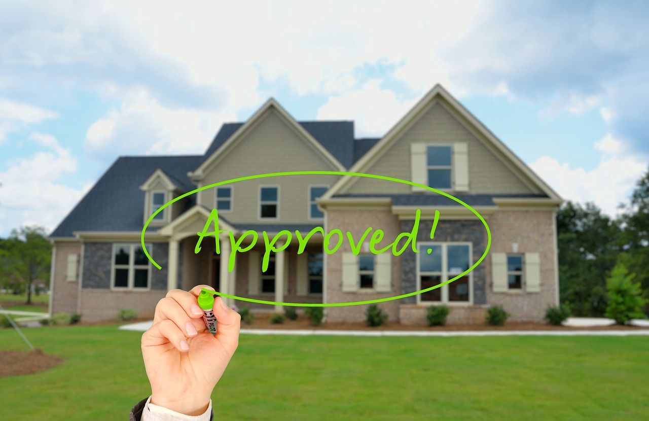 a person is writing the word approved in front of a house
