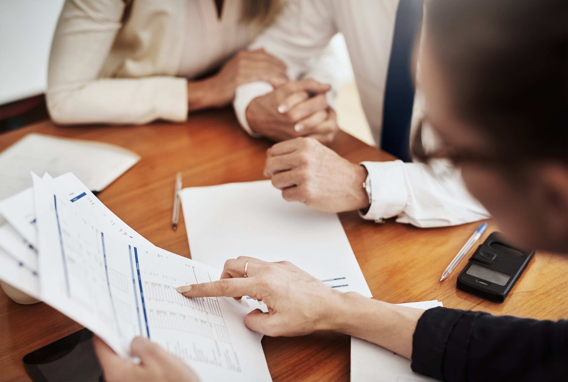 a group of people are sitting at a table looking at papers