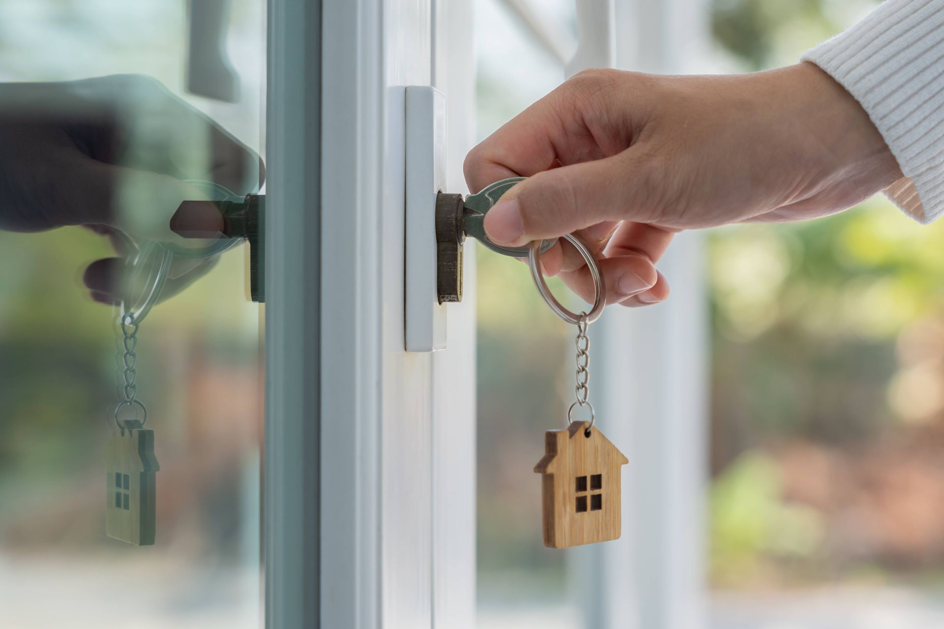 a person is opening a door with a key and a house keychain