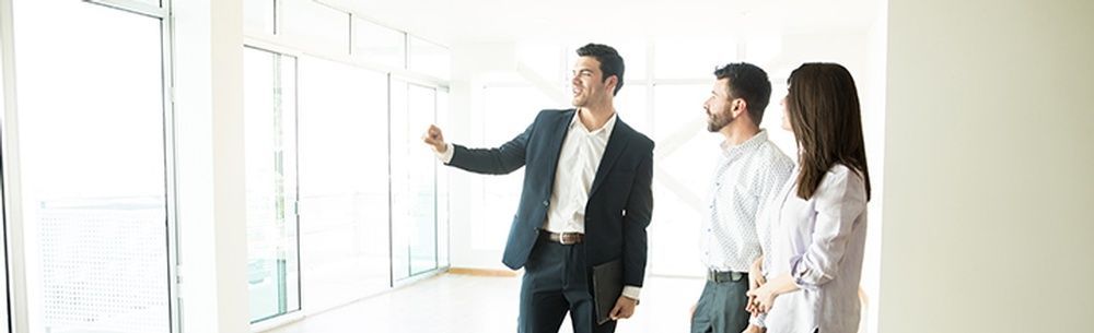 a group of people are standing in an empty room looking at a window