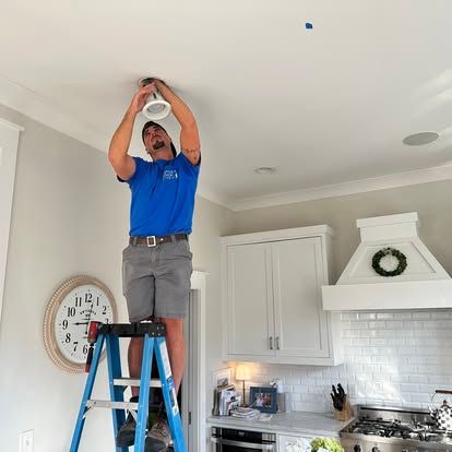 A man and a woman are standing next to each other on a ladder.