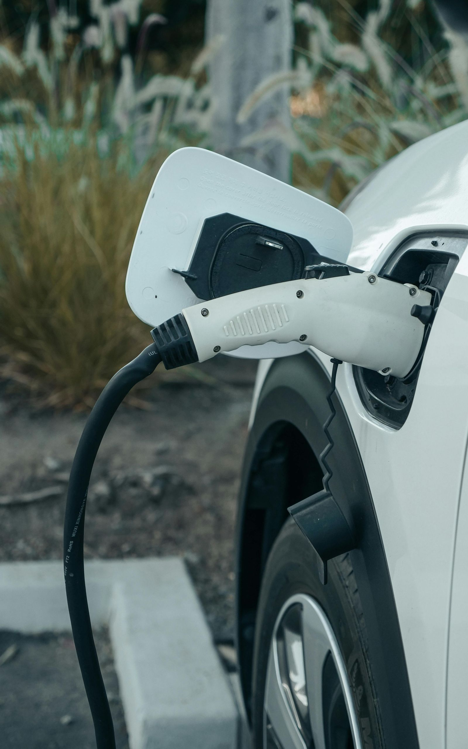 A beige Generac standby generator positioned outdoors in front of blue siding and a small window.