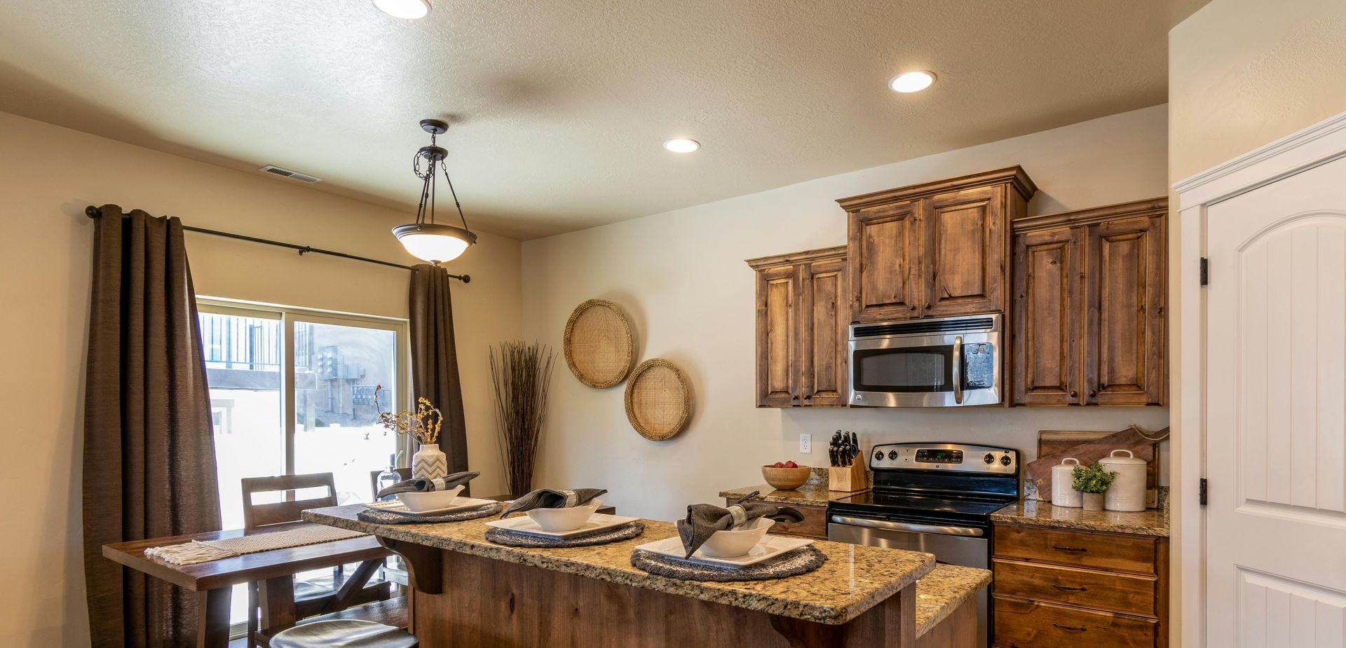Kitchen with wooden cabinets, granite countertops, and a dining table.
