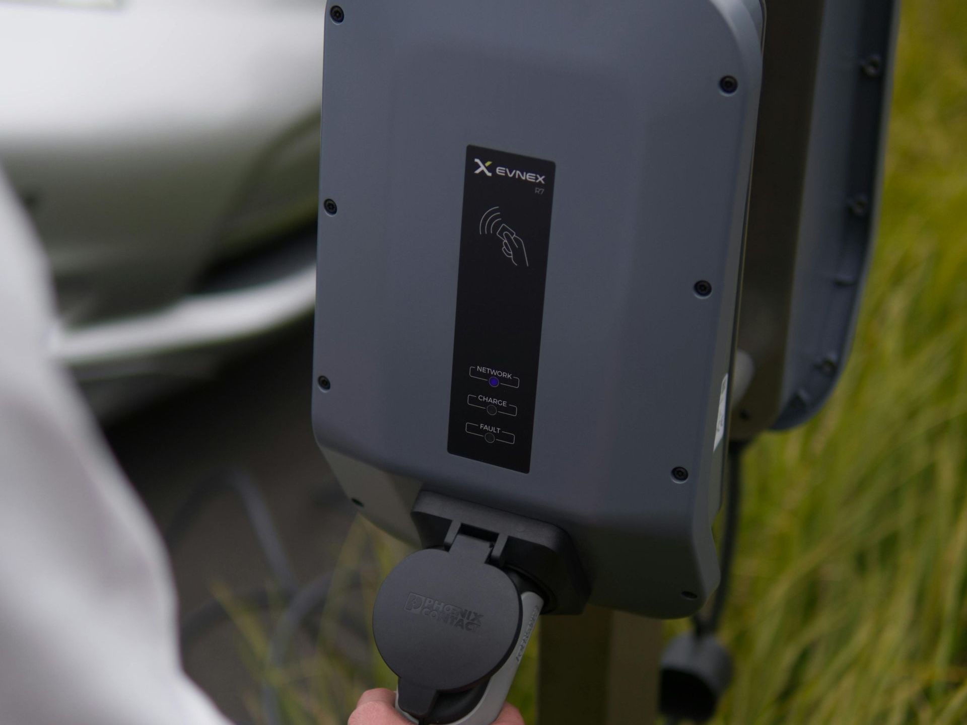 A person is charging an electric car at a charging station