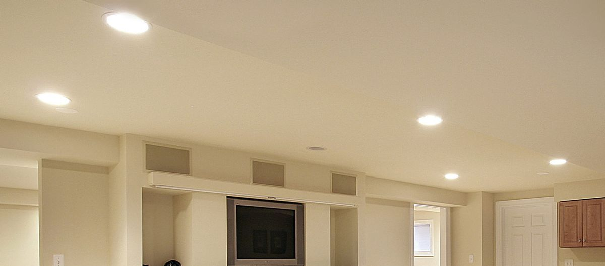 Kitchen interior with wooden cabinets, microwave, and decorative wall hangings.