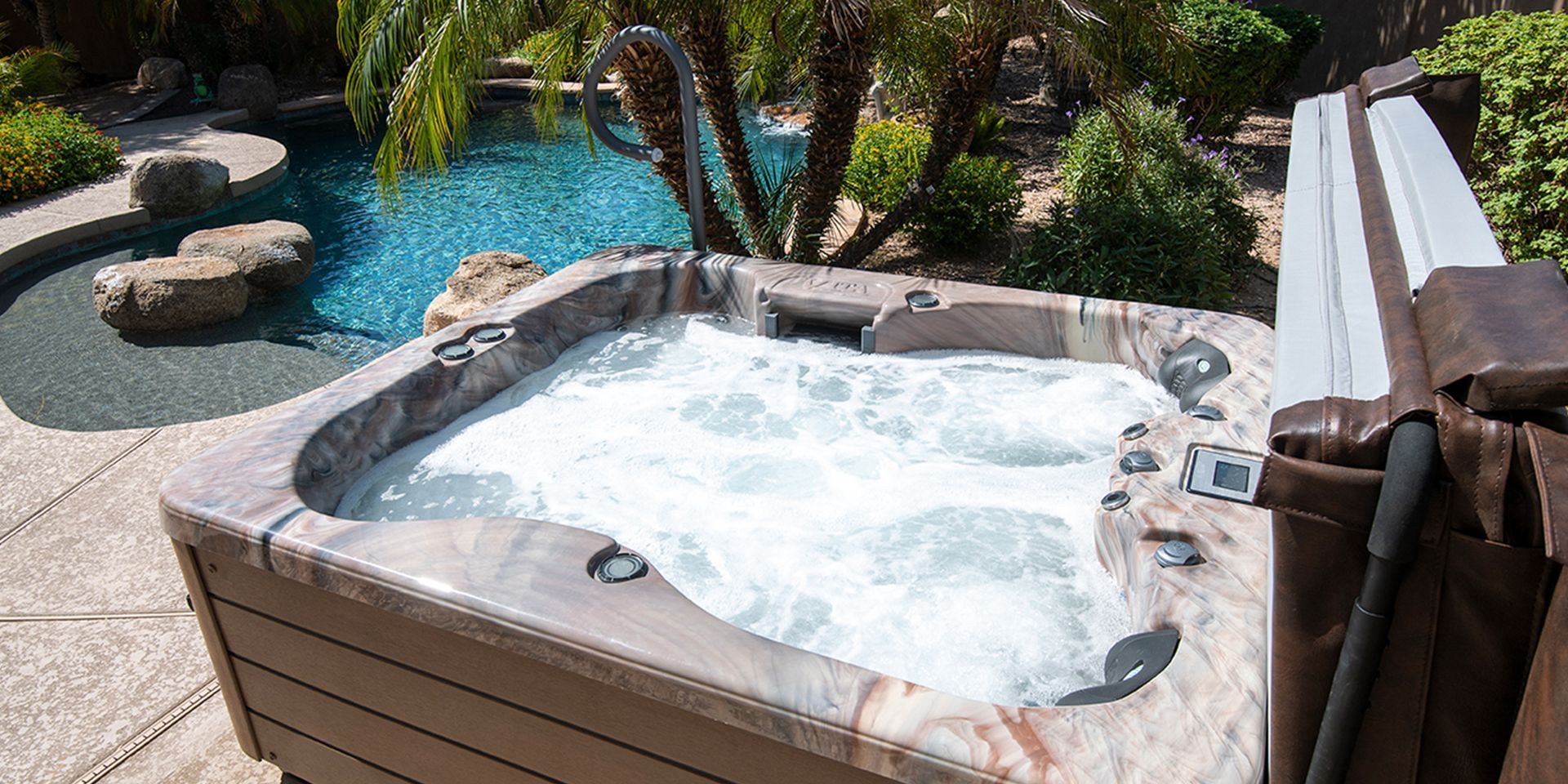 Hot tub with bubbling water next to a swimming pool in a sunny outdoor setting.