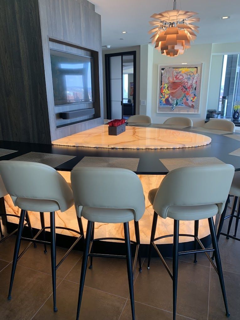 A dining room with a table and chairs and a painting on the wall