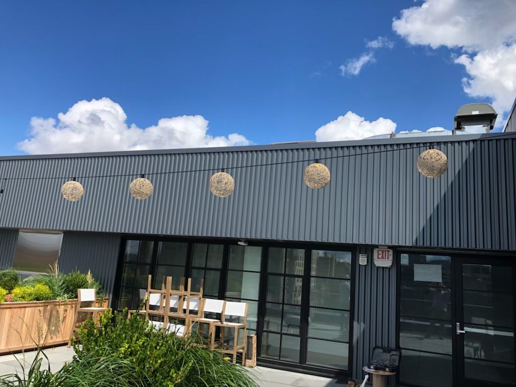 A building with a lot of windows and a lot of plants on the side of it.