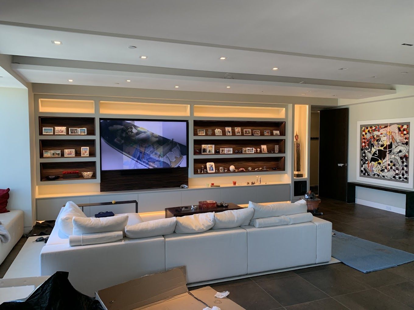 A living room with a white couch and a flat screen tv.