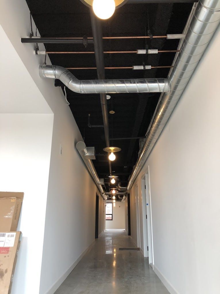 A long hallway with pipes hanging from the ceiling