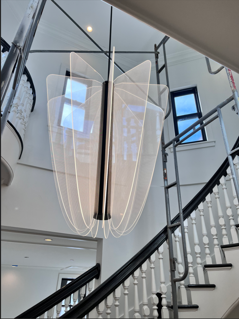 A staircase with a chandelier hanging from the ceiling