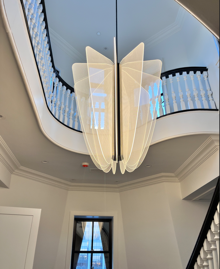 A large chandelier is hanging from the ceiling in a hallway