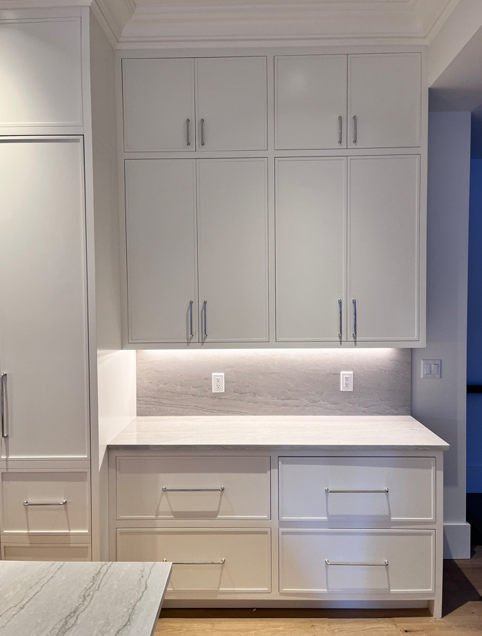 A kitchen with white cabinets and drawers and a counter top