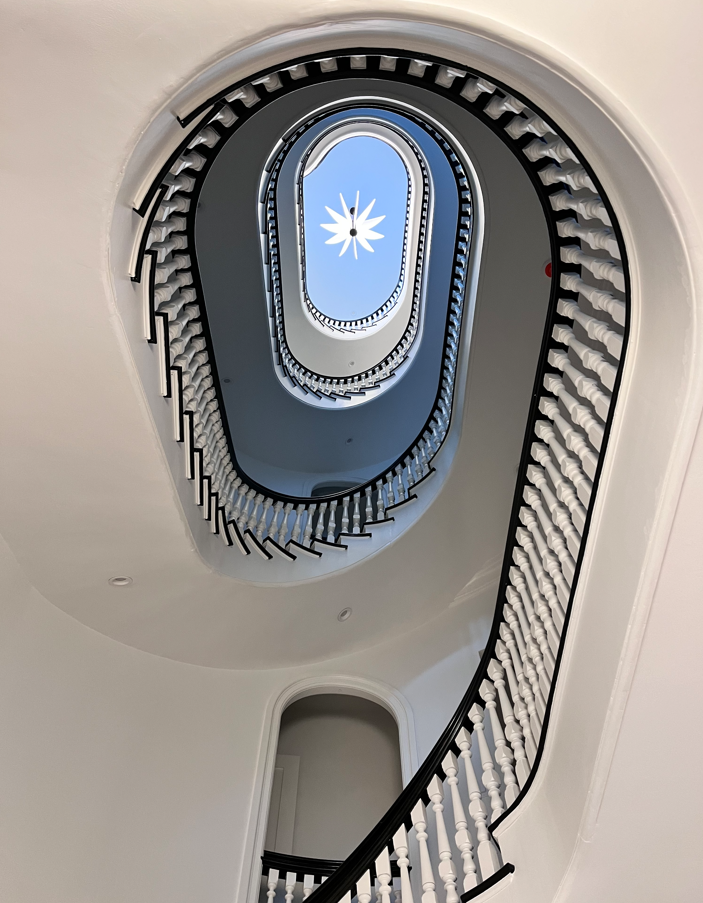 Looking up a spiral staircase with a blue sky in the background