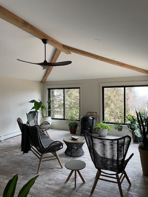 A living room with chairs a table and a ceiling fan