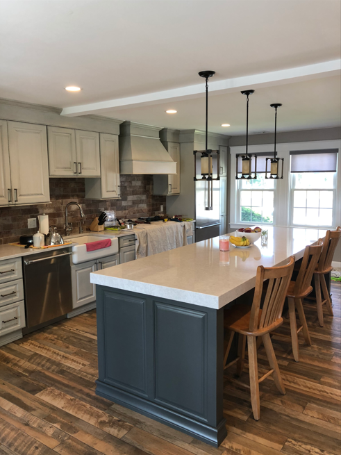 A kitchen with a large island and wooden chairs