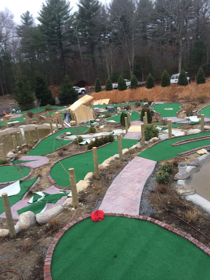 An aerial view of a mini golf course with trees in the background