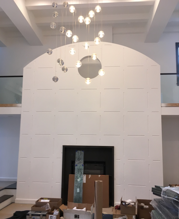 A living room with a fireplace and a chandelier hanging from the ceiling