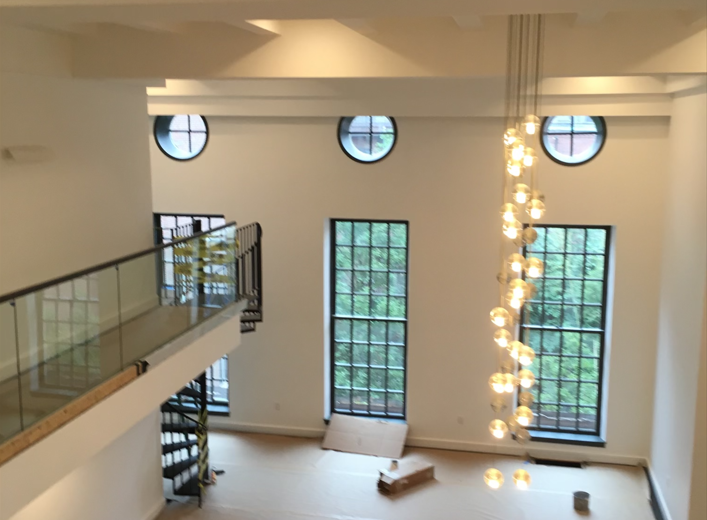 A large room with a spiral staircase and lots of windows