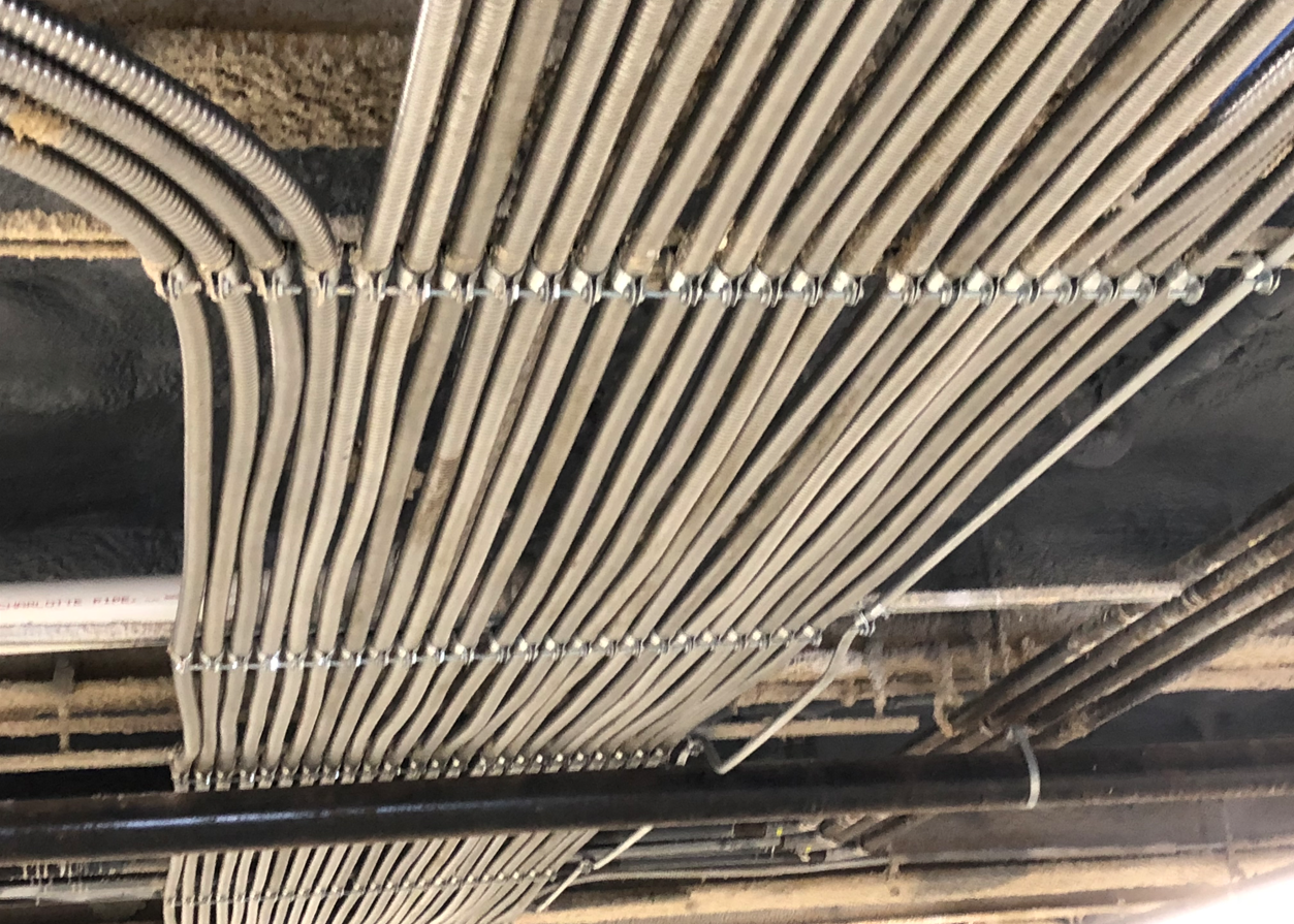 A bunch of wires are hanging from the ceiling of a building.