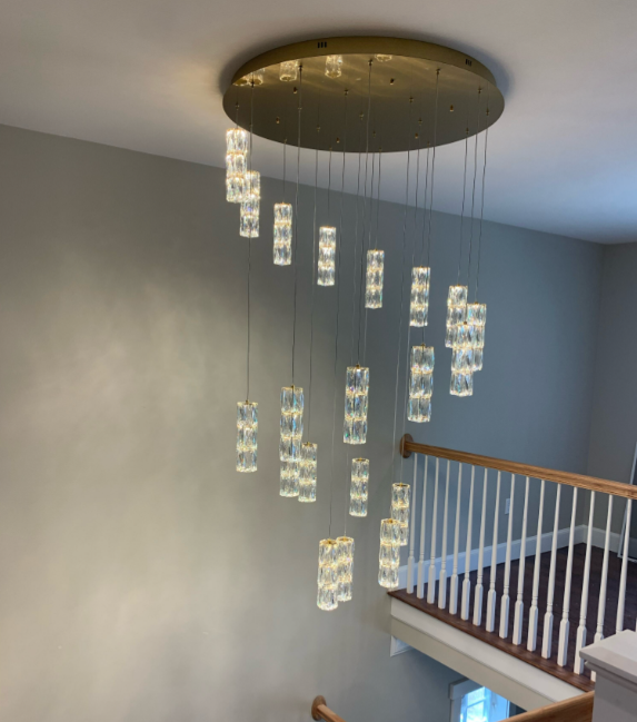 A staircase with a chandelier hanging from the ceiling
