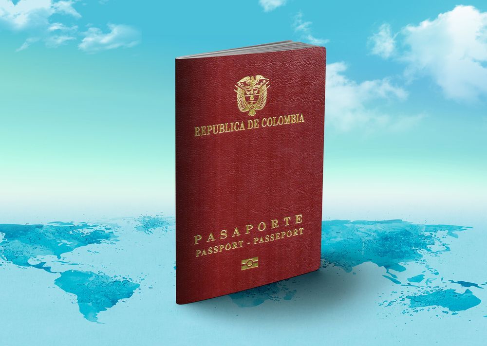 Pasaporte colombiano sobre un mapamundi y un cielo azul de fondo.