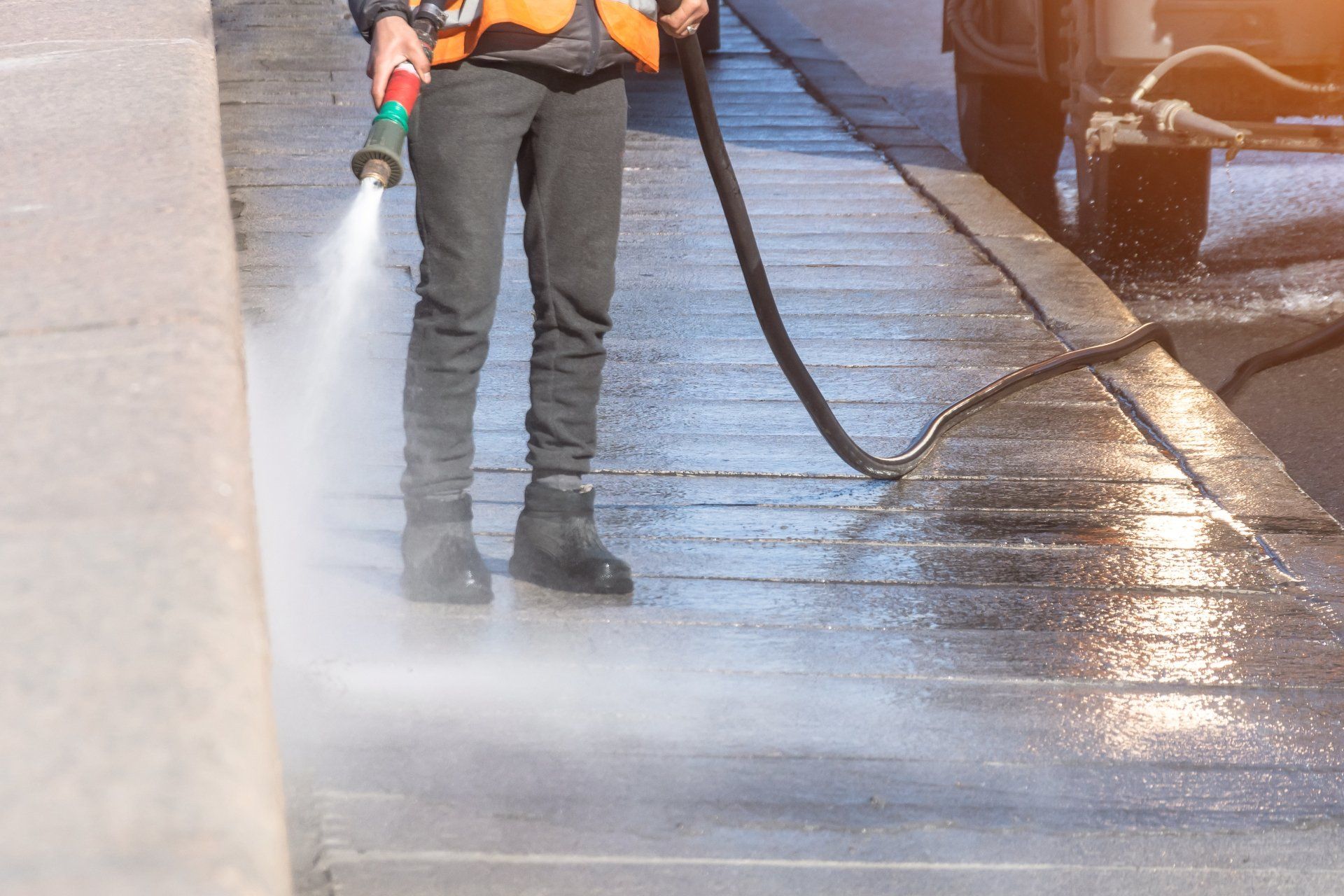 worker cleaning concrete with power washer