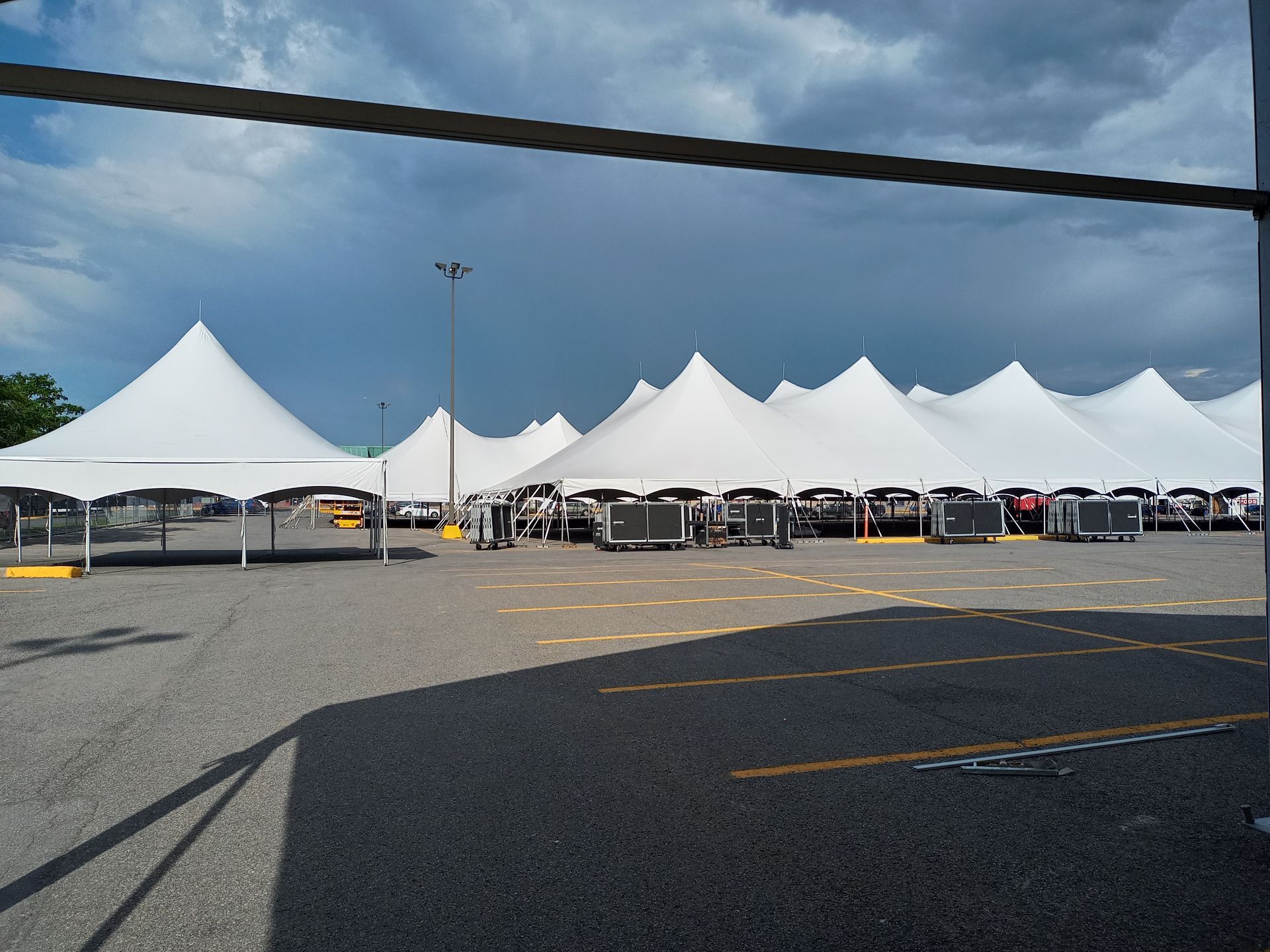 De nombreuses tentes blanches sont alignées sur un parking