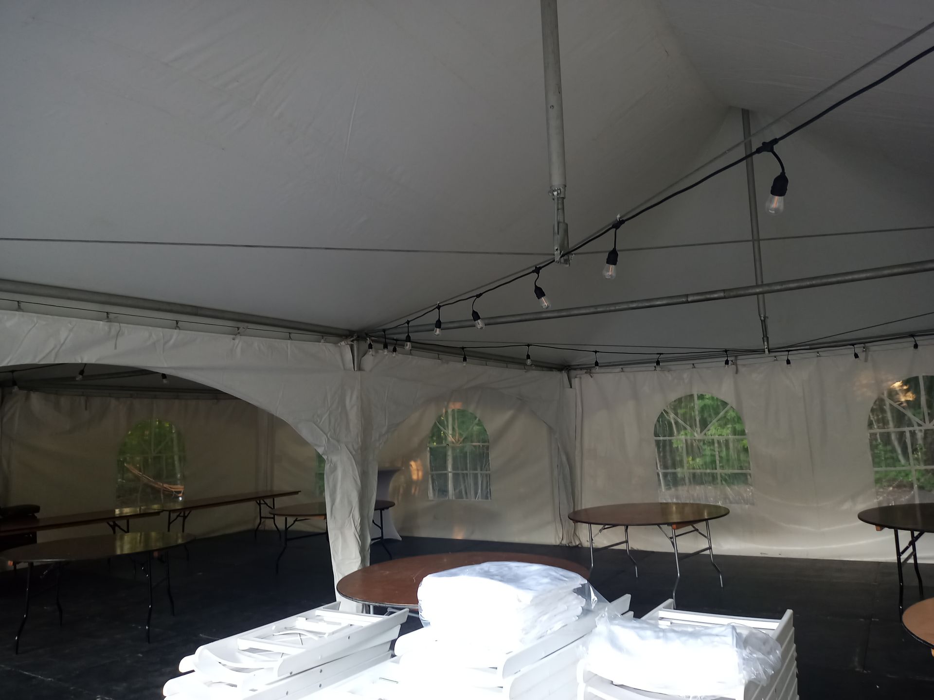Une tente blanche avec des tables et des chaises à l intérieur