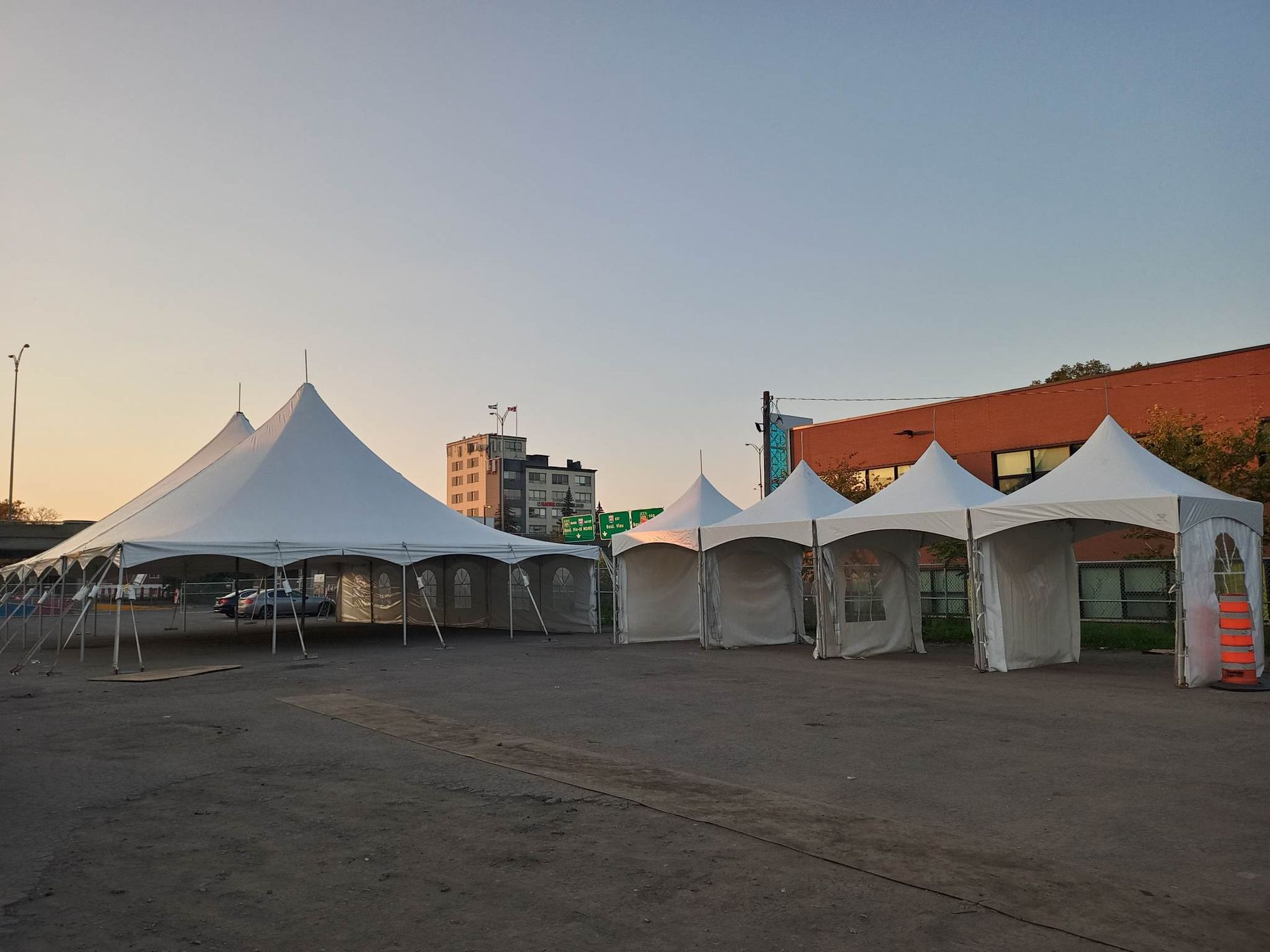 Une rangée de tentes blanches sont alignées dans un parking
