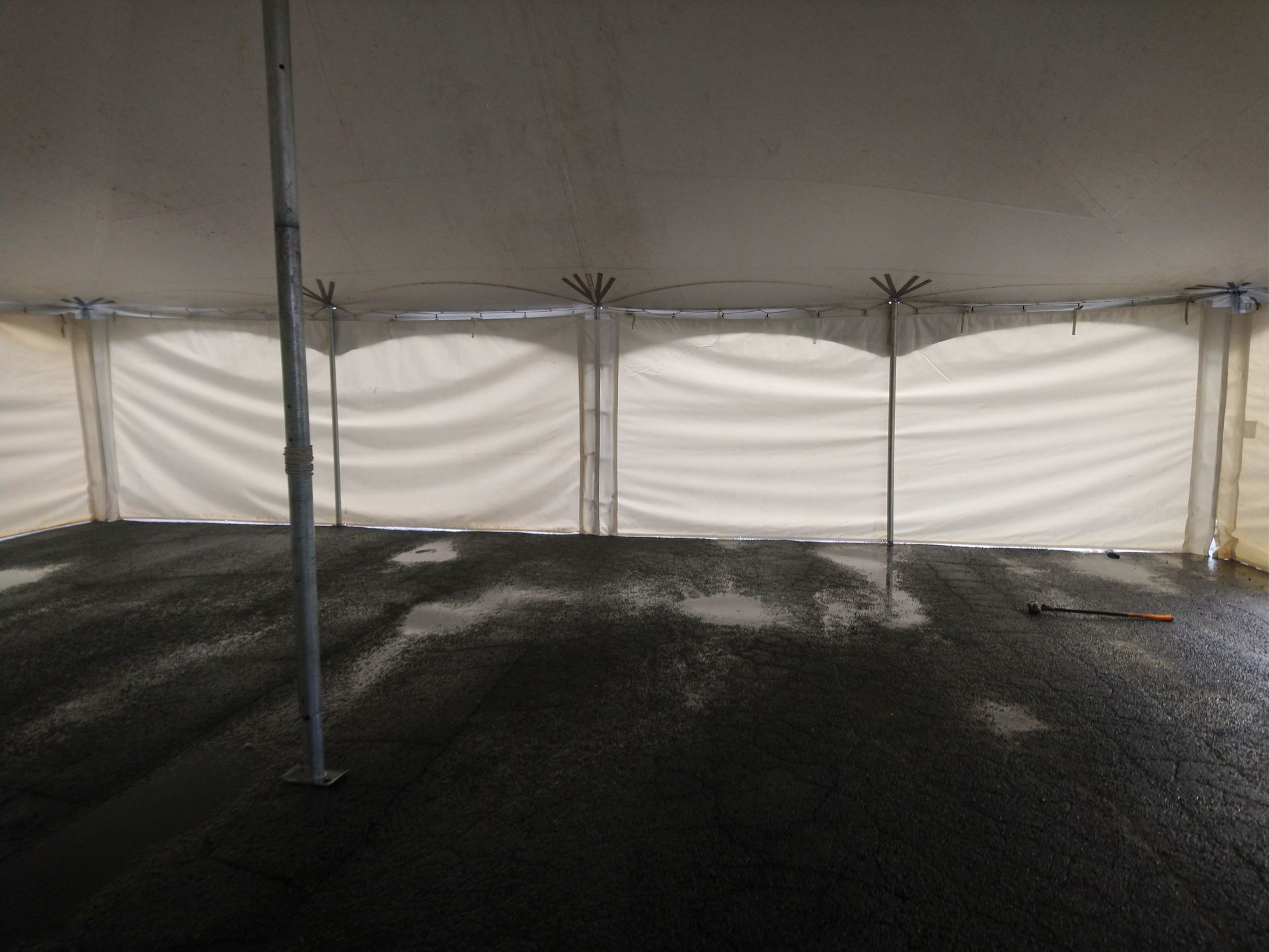 L intérieur d une tente avec un sol noir et des murs blancs.