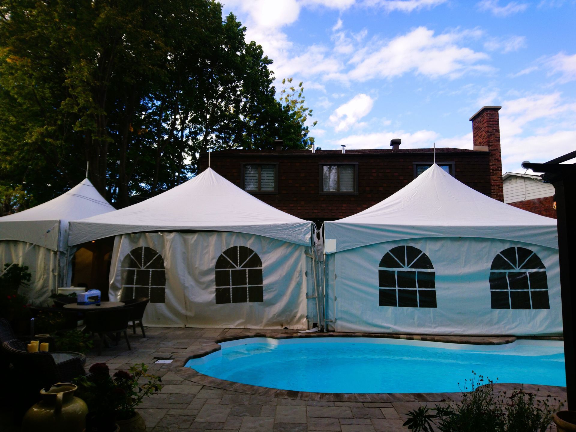 Une piscine entourée de tentes et d une maison