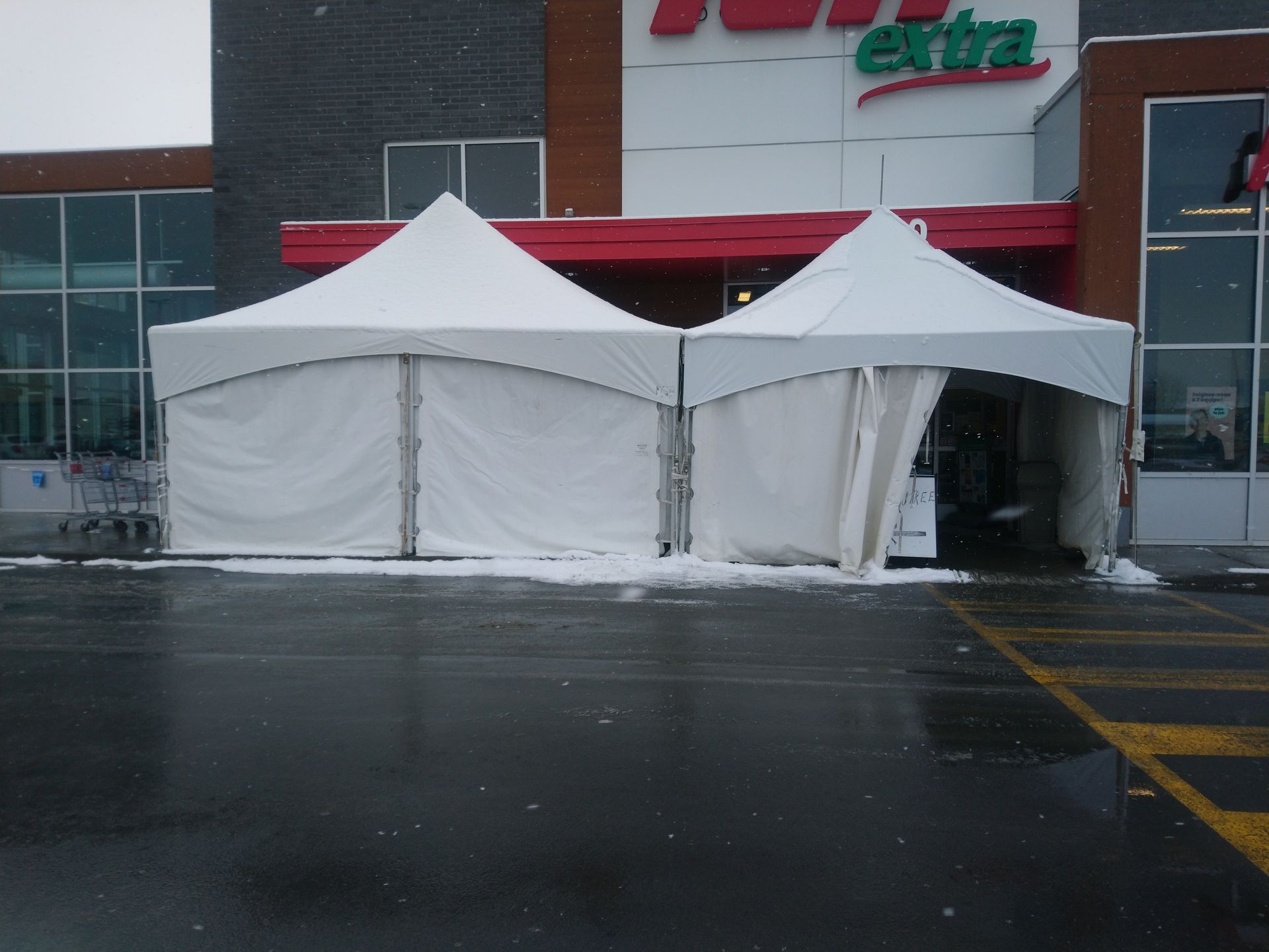 Deux tentes blanches devant un magasin qui dit extra
