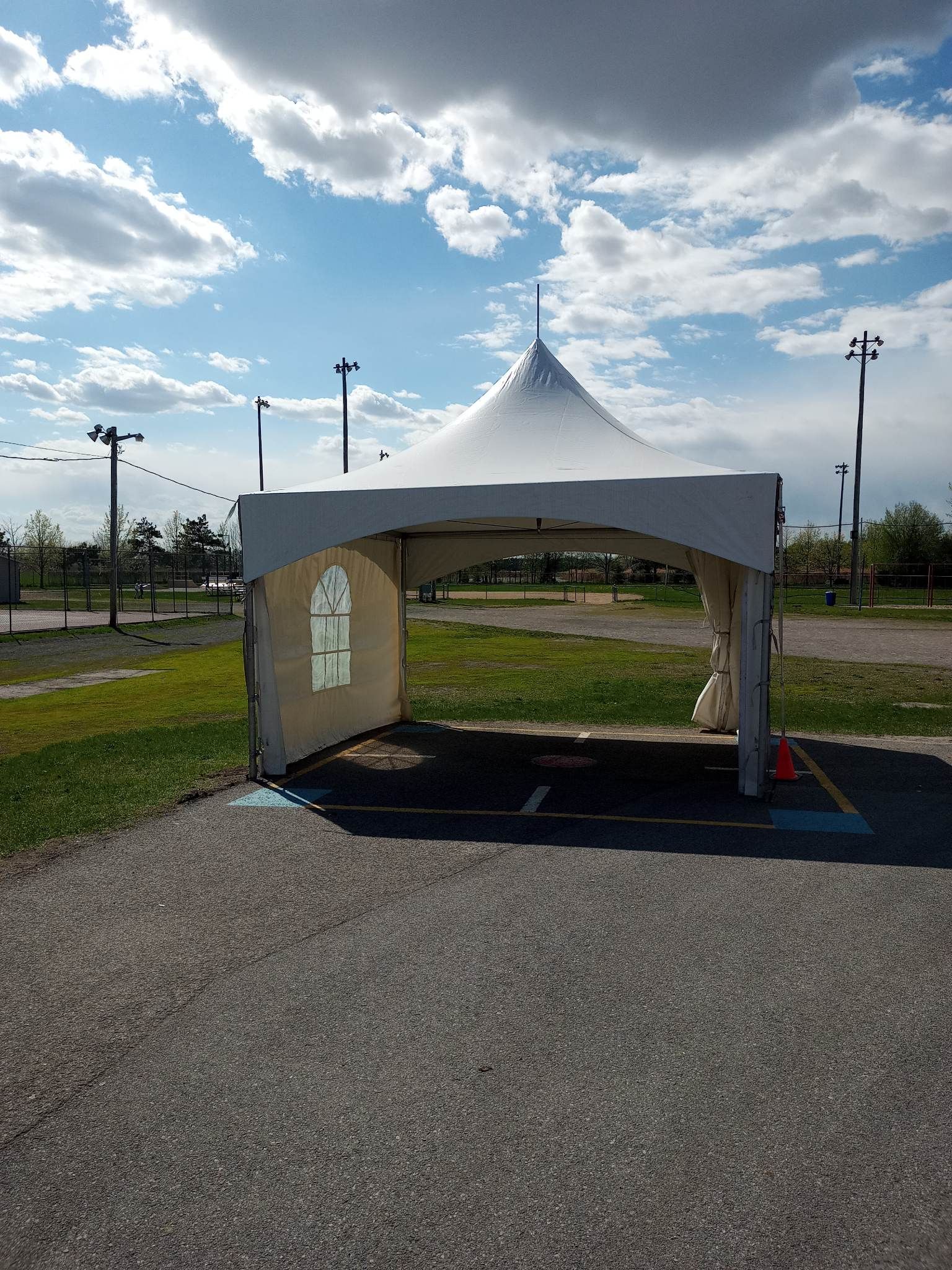Une tente blanche trône au milieu d’un parking.