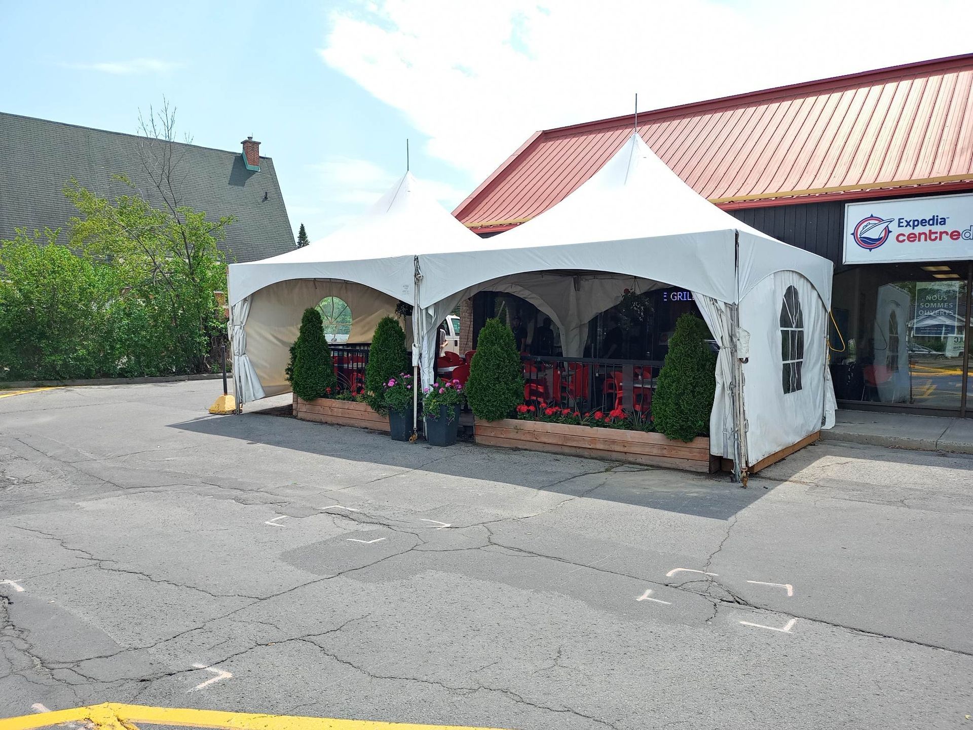 Deux tentes blanches sont installées devant un bâtiment.