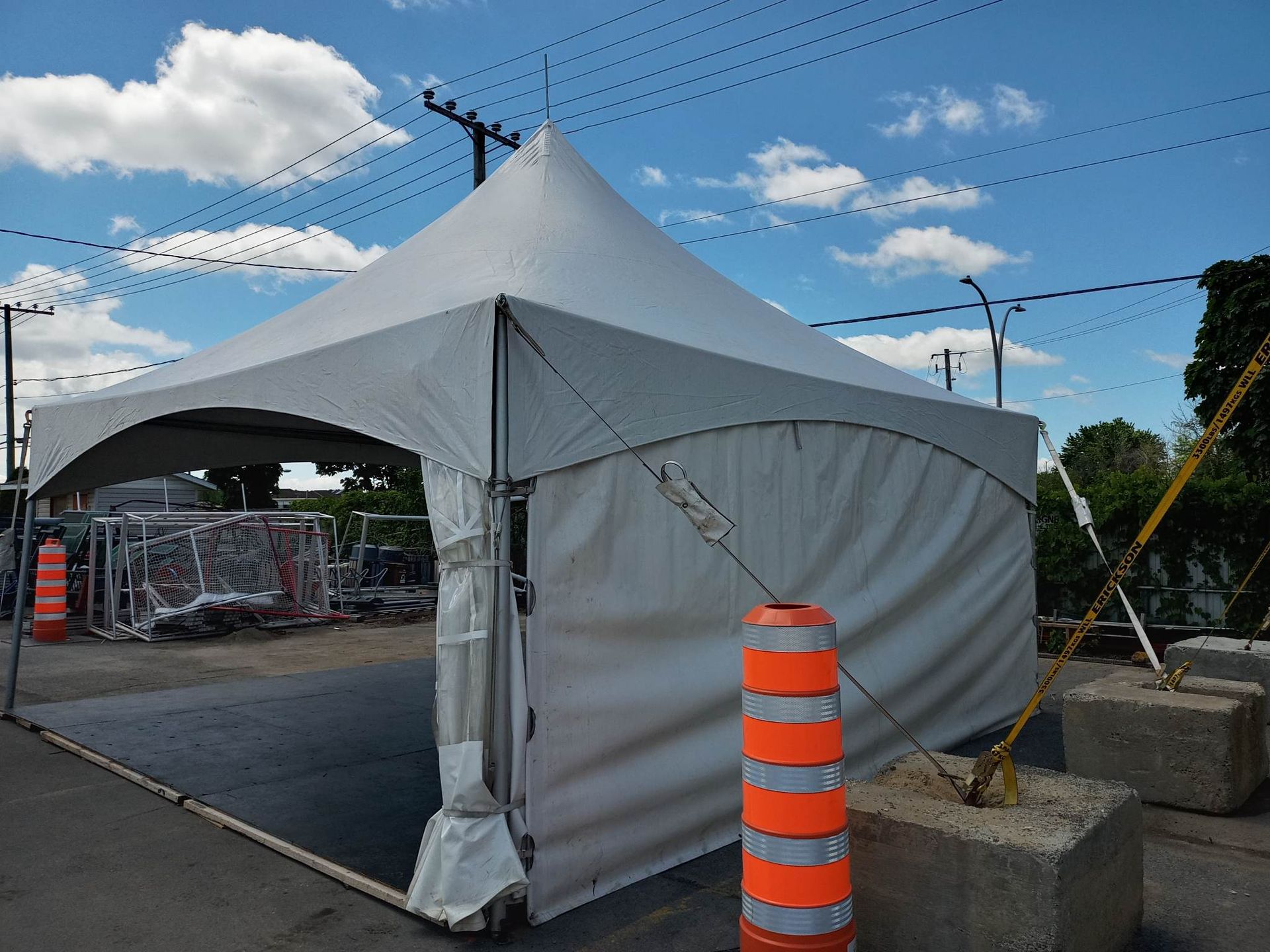 Une tente blanche est posée au milieu d’un parking