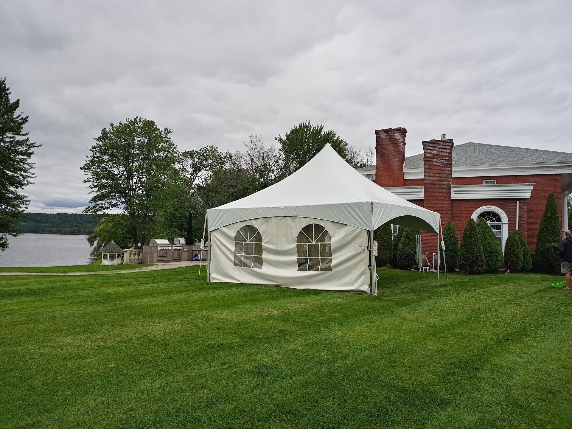 Une tente blanche est installée au milieu d’un champ verdoyant.