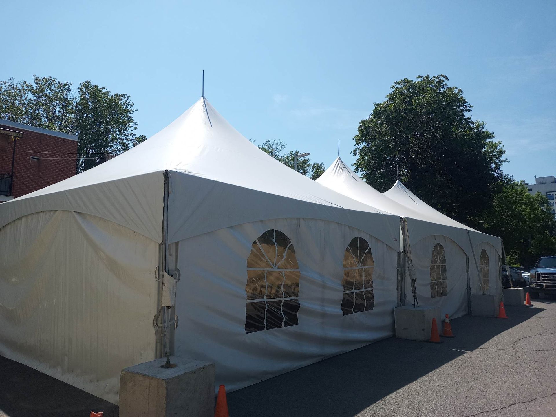 Une grande tente blanche se trouve dans un parking