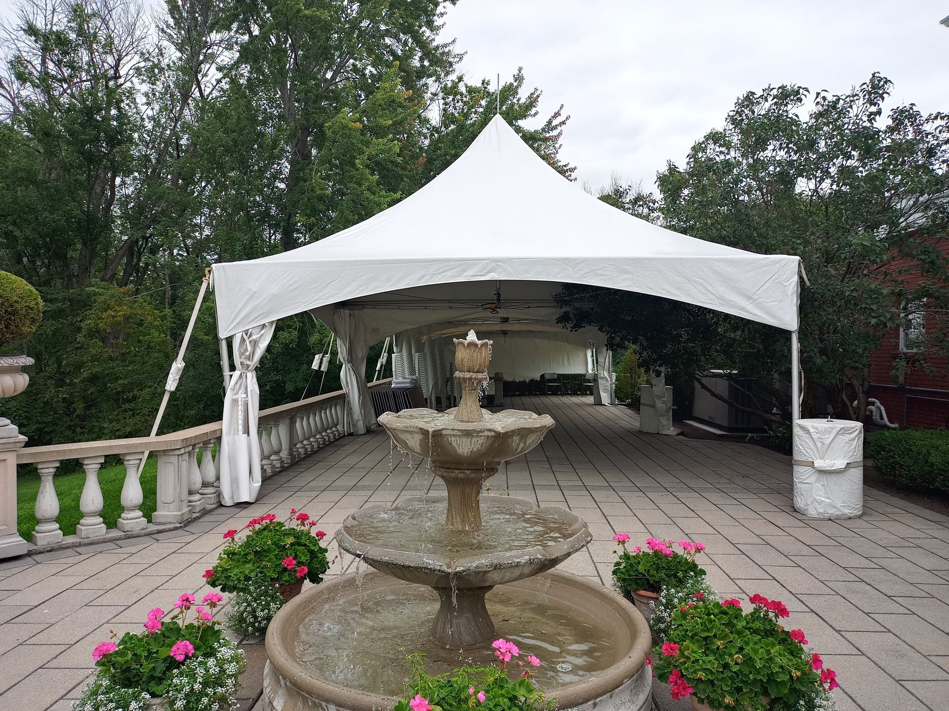 Il y a une fontaine devant une tente blanche.