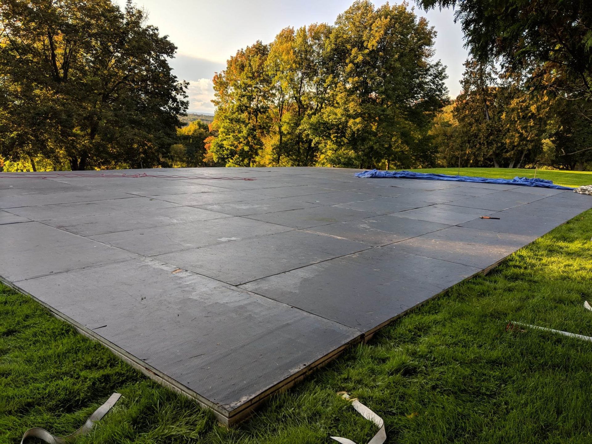 Une grande piste de danse en bois se trouve au sommet d’un champ verdoyant.