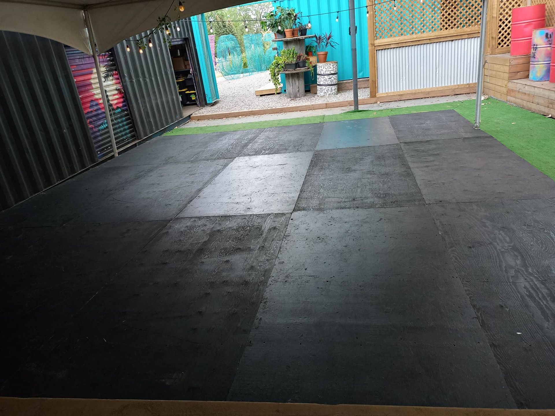 Un grand carrelage noir dans une cour avec une clôture en arrière-plan.