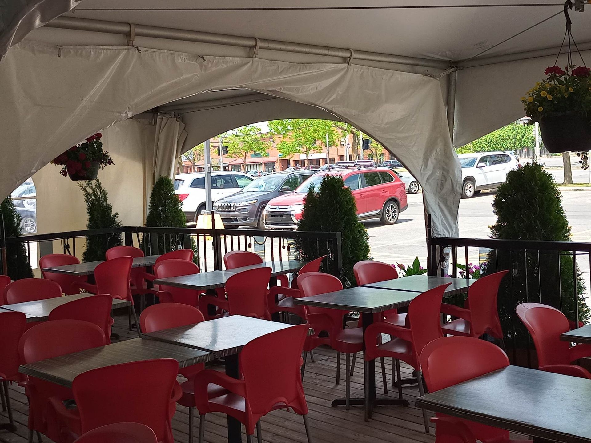 Un restaurant avec des chaises et des tables rouges sous une tente.