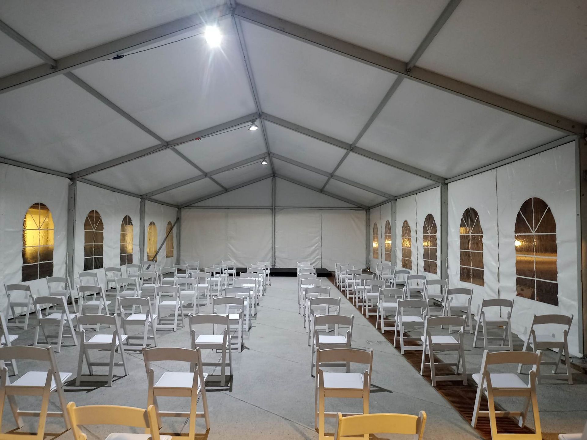 Une grande tente blanche avec des tables et des chaises à l intérieur