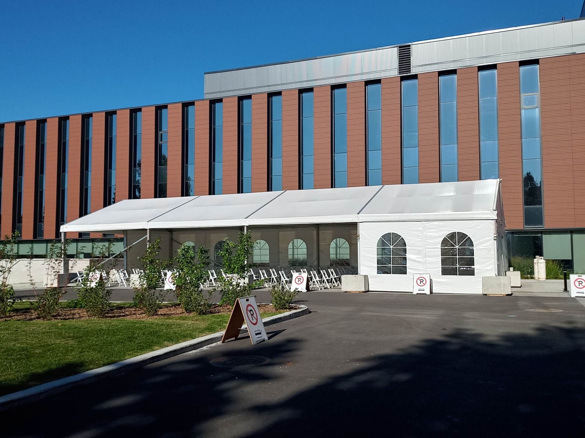 Un grand bâtiment en brique avec une tente blanche devant lui