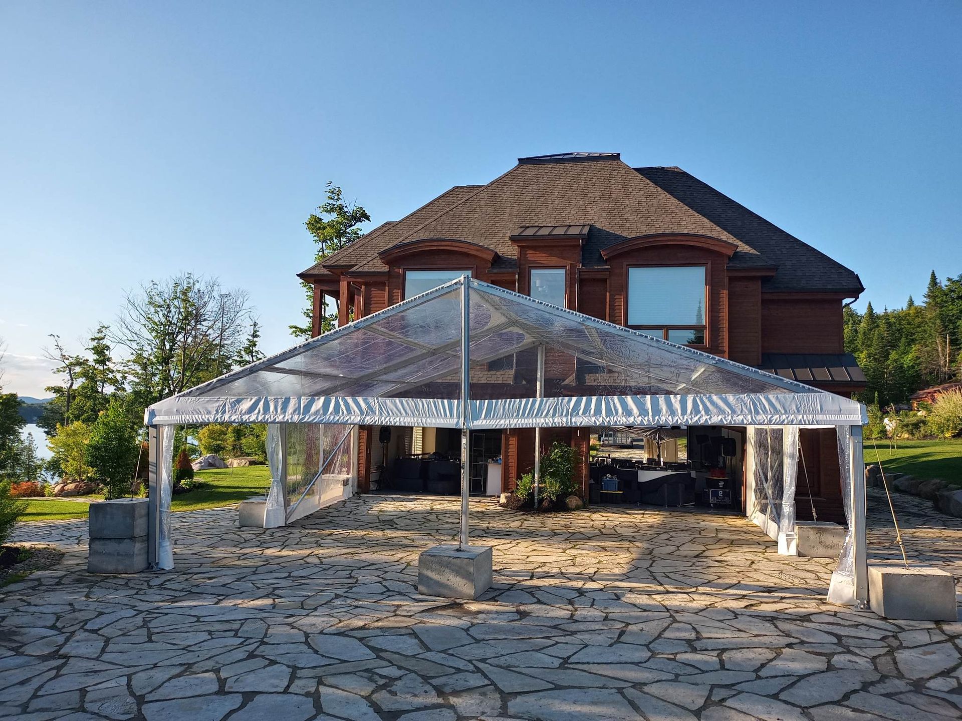 Une grande maison avec une tente claire devant.