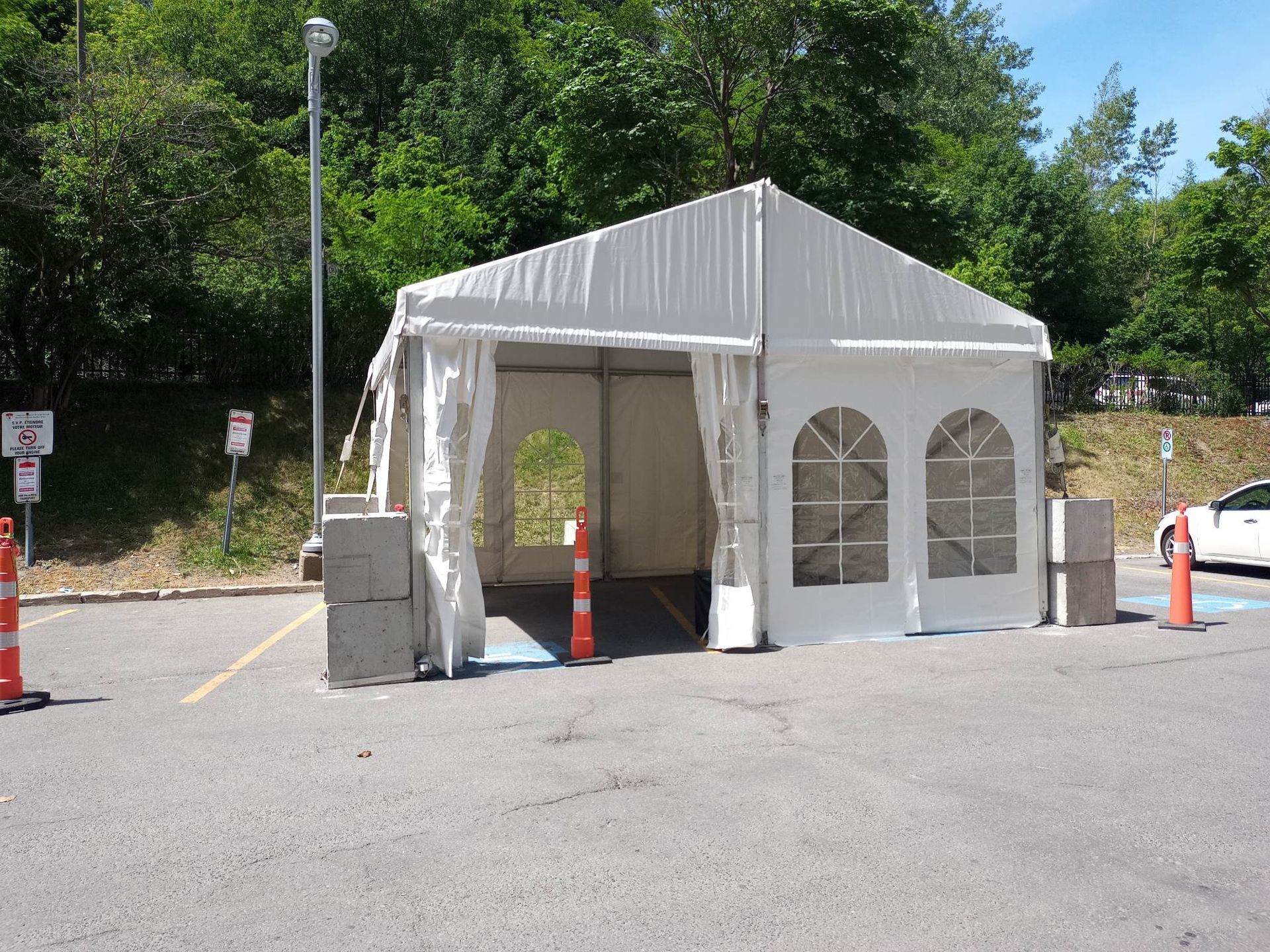 Une tente blanche se trouve au milieu d un parking