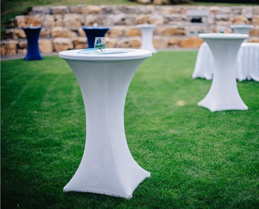 Une rangée de tables blanches posées au sommet d’un champ verdoyant.