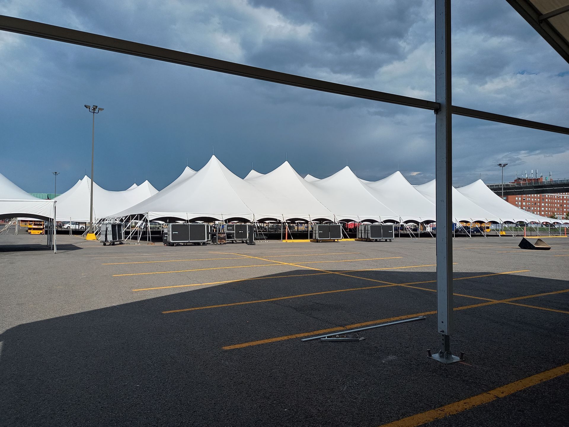 De nombreuses tentes blanches sont alignées sur un parking